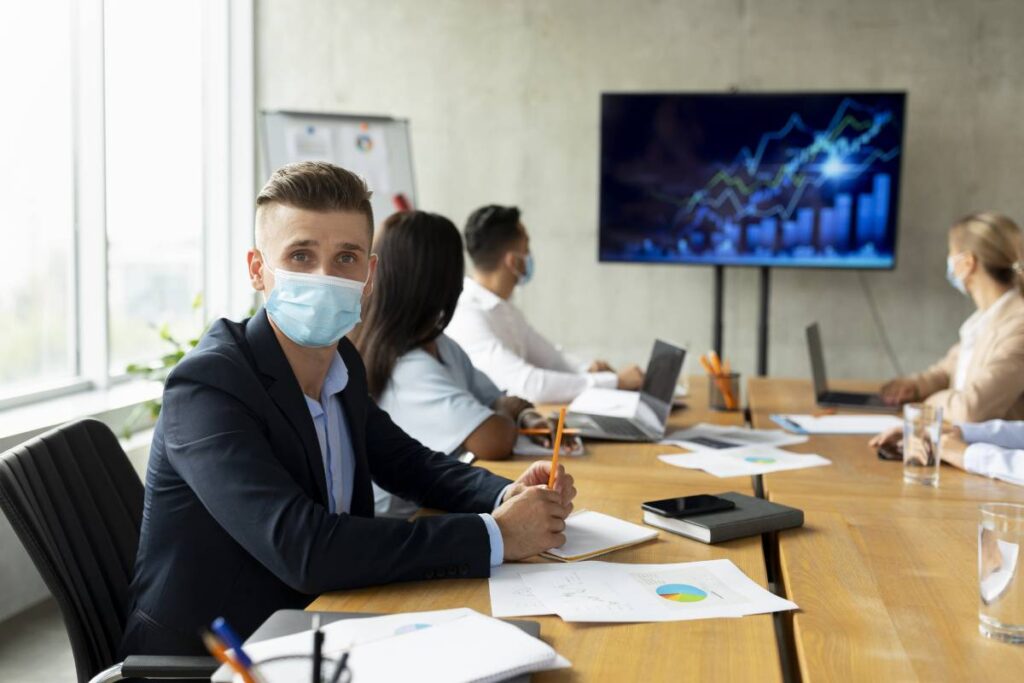 Workplace Healthcare, Multiethnic Business Team Wearing Medical Masks Having Meeting In Office
