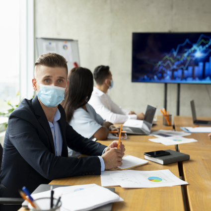 Workplace Healthcare. Multiethnic Business Team Wearing Medical Masks Having Meeting In Office