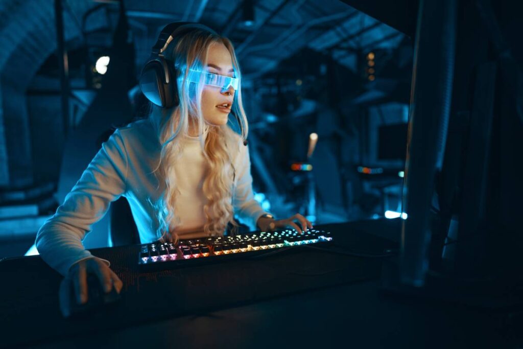 Blonde in cyberpunk glasses plays computer games, fascinated by technology and the virtual world