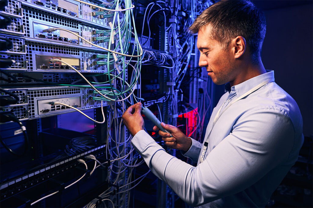 Focused data center employee checking cabling infrastructure - featured