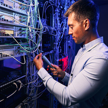 Focused data center employee checking cabling infrastructure